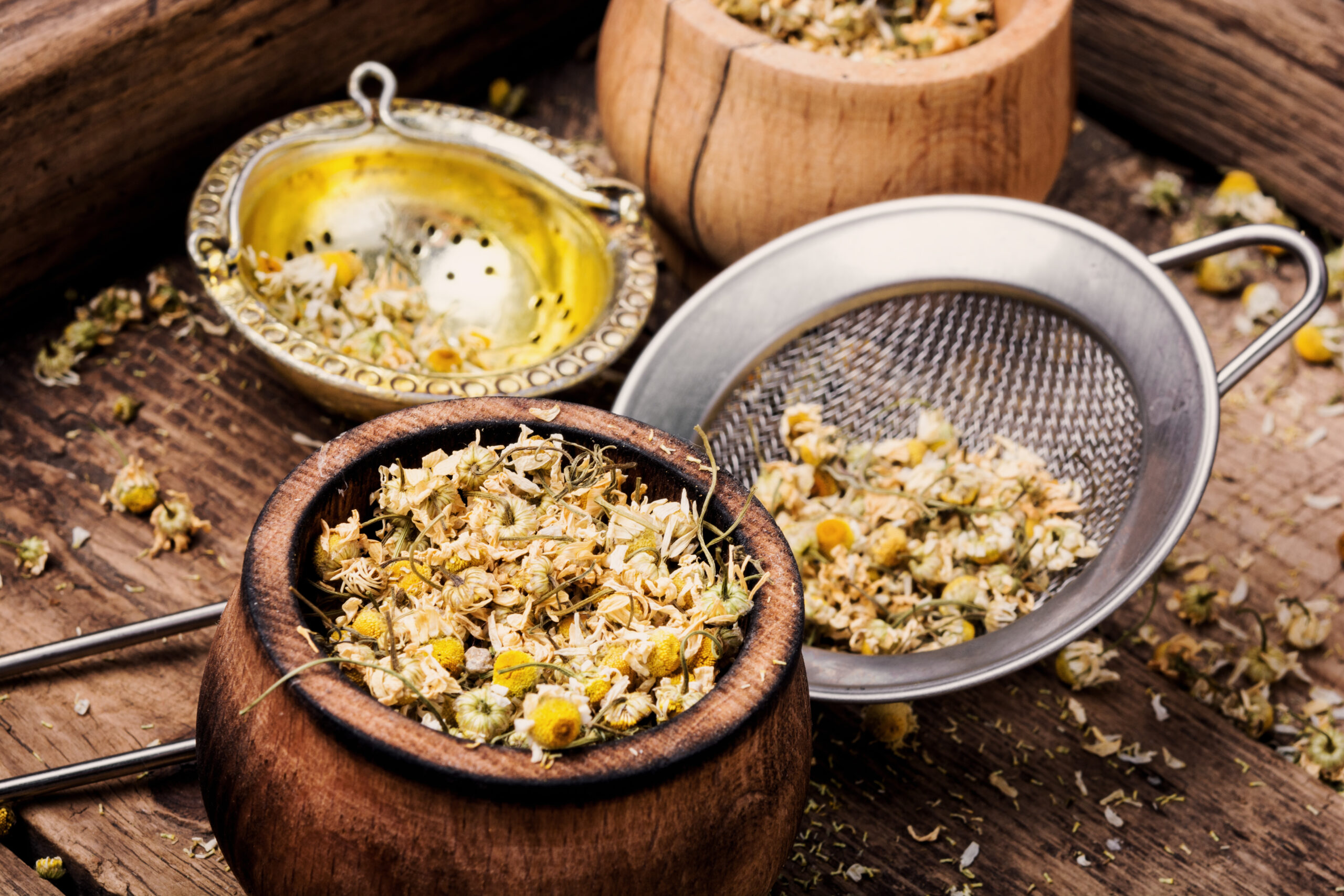 Dried chamomile flowers on wooden table.Alternative medicine.Bowls of dry medicinal herbs